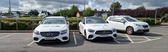 2 white Mercedes parked 